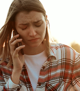 Distressed woman talking on mobile phone